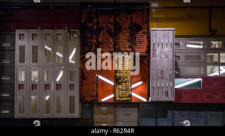 Parete di armadietti illuminati da una luce al neon tubi Foto Stock