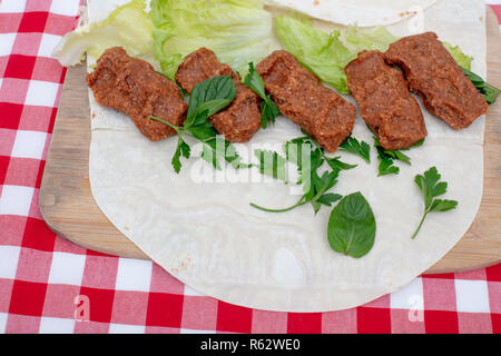Tradizionale turco Cigkofte antipasto con lavash, , gli ingredienti sono la carne cruda di bulgur ,cipolla, pomodoro, peperoncino e sale Foto Stock