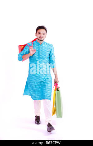Uomo indiano in usura etnica con le borse della spesa, isolato su sfondo bianco Foto Stock