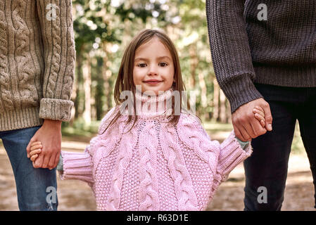 Close-up foto di carino bambina è in possesso di genitori mani durante la famiglia a piedi Foto Stock