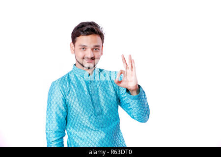 Uomo indiano in usura etnica , che mostra il gesto con la mano , isolate su sfondo bianco Foto Stock