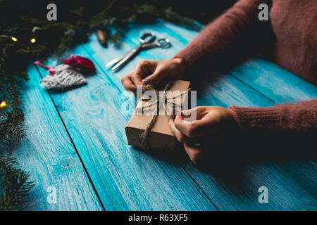 Donna imballaggio di un regalo di Natale. Foto Stock