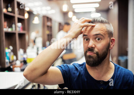 Hipster uomo client haidresser visita e un parrucchiere in un barbiere. Foto Stock