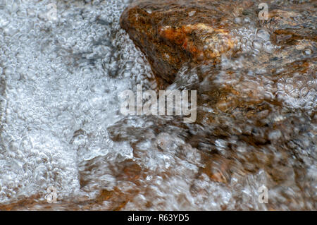 Il gorgogliamento Brook. close up di acqua che scorre in un piccolo ruscello fotografato in Stubaital, Tirolo, Austria Foto Stock