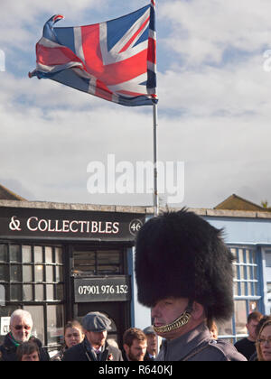 Un orso pelle hat è indossata da un soldato da uno di le protezioni per i piedi poste reggimenti sul giorno del ricordo a Rottingdean Foto Stock