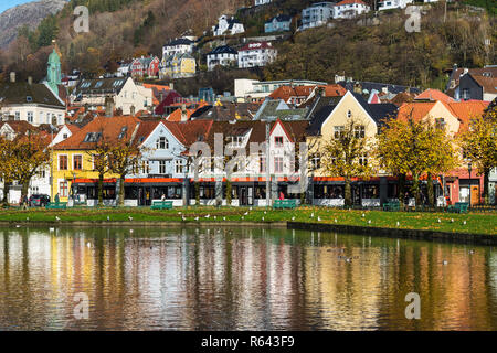 Autunno a Bergen, Norvegia. Lille Lungegaardsvannet lago e piccoli edifici lungo Kaigaten street. Bybanen luce treno in Kaigaten street. Foto Stock