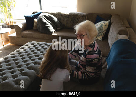 Nonna e nipote di interagire gli uni con gli altri sul divano nel soggiorno Foto Stock