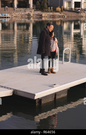 Nonna e nipote in piedi sul molo vicino a lato lago Foto Stock