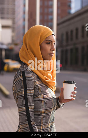 Donna con caffè in via della città Foto Stock