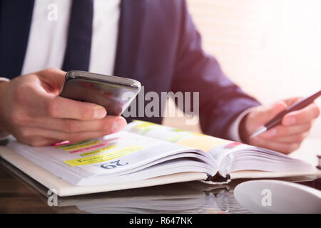 Agente utilizzando il telefono cellulare Foto Stock