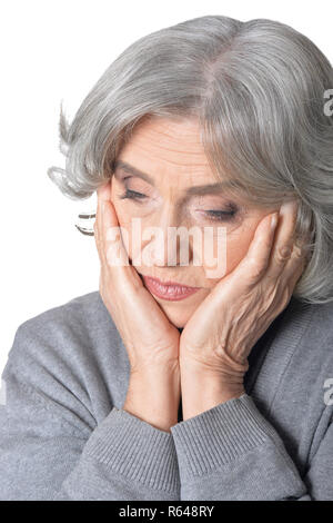 Senior donna in grigio blusa con mal di testa su sfondo bianco Foto Stock