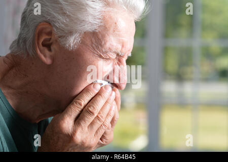 Ritratto di uomo anziano avente un mal di denti, tenendo fazzoletto Foto Stock