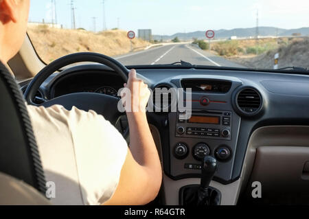 Autista donna avvicinandosi al sorpasso vietato tratto stradale. All'interno dell'auto visualizzare Foto Stock