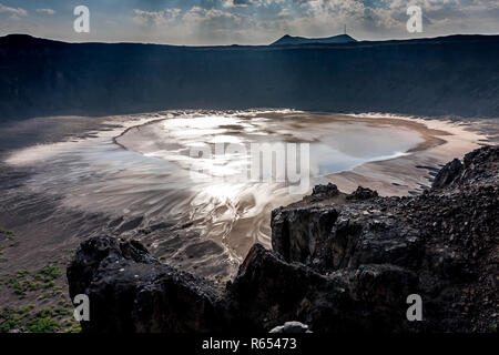 Il sole si riflette nell'acqua del lago in fondo al cratere Wahbah, Arabia Saudita Foto Stock