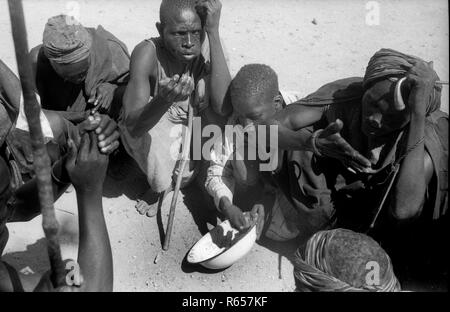 Anni Cinquanta la tribù indigene persone che condividono una piccola ciotola di cibo in Camerun in Africa Foto Stock