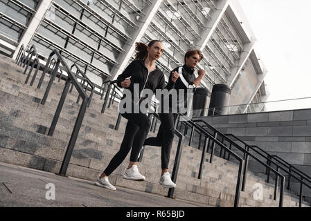 La mattina presto allenamento. Coppia giovane in esecuzione al piano di sotto Foto Stock