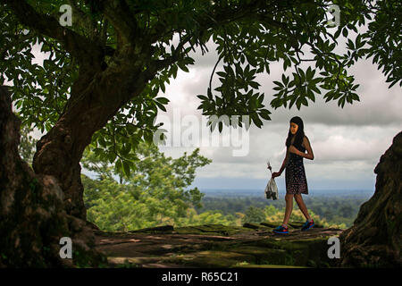 Ragazza locale in passeggiata che conduce a livelli superiori di Wat Phu Champasak Laos Foto Stock