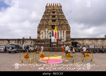 Belur, Karnataka, India - 2 Novembre 2013: pietra marrone Gopuram di ingresso principale visto dalla strada bianca contro il cielo nuvoloso. Il Karnataka Rajyotsava segno Foto Stock