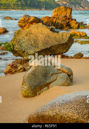 Una costa rocciosa spiaggia con bellissime rocce testurizzata a Vung Lam Bay Vietnam. Foto Stock