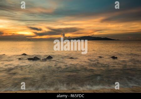 Una bella mattina d'oro in Nha Trang Vietnam poco dopo l'alba con un variopinto cielo nuvoloso. Foto Stock