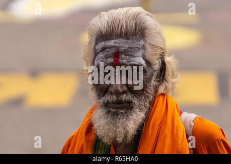 Belur, Karnataka, India - 2 Novembre 2013: Chennakeshava Tempio. Primo piano del viso ritratto di dark scuoiati Sadhu con i capelli bianchi e la barba e orang Foto Stock