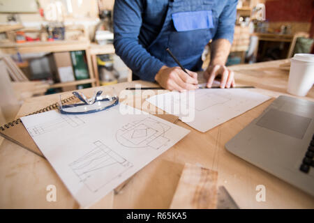 Irriconoscibile Carpenter piani di disegno Foto Stock