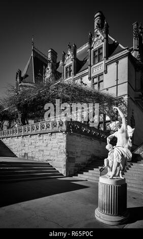 "La lezione di ballo' statua fiancheggia il pergolato di glicine e il Biltmore House al Biltmore Estate in Asheville, NC, Stati Uniti d'America. Foto Stock