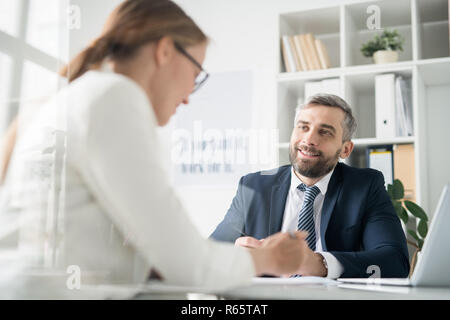 Happy businessman a discutere questioni di lavoro con i colleghi Foto Stock