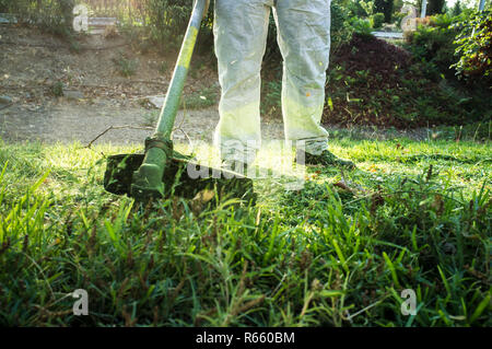 Uomo da lavoro giardiniere caucasico tagliaerba manuale tagliaerba  tagliaerba a mano tagliaerba o pinzetta elettrica o taglierina a spazzola  Prato Mace Gasoline primo piano Foto stock - Alamy