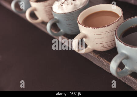 Fila di tazze da caffè con caffè fresco su un tavolo di legno. Lo spazio negativo per il testo Foto Stock