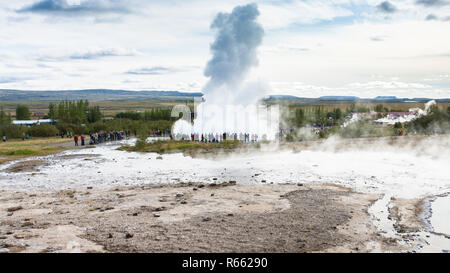 I turisti vicino Strokkur geyser in Haukadalur Foto Stock