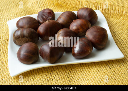 Mature castagne vicino. Materie Le Castagne per Natale. Dolci freschi di castagno. Foto Stock