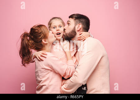 Felice famiglia giovane con una piccola figlia in posa insieme Foto Stock