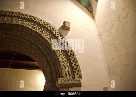 Dettaglio scolpito sull arco di pietra in vista interna di Penmon Priory Seiriol St è la Chiesa, Anglesey, Galles, Regno Unito Foto Stock