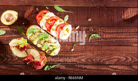 Raccolta di tre diversi tipi di bruschette sul tavolo di legno dello sfondo. Foto Stock