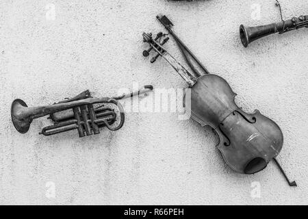 In stile retrò strumenti musicali appese ad una parete, un musical vintage vista di un violino e una vecchia tromba ci trasportano attorno alla storia di vecchi tempi Foto Stock