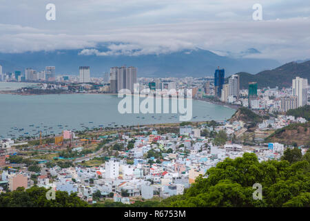 Holiday resort Nha Trang Vietnam in un giorno nuvoloso da un punto di vista a nord della città. Con lo sfondo delle montagne e del turchese del mare della Cina meridionale a sinistra. Foto Stock