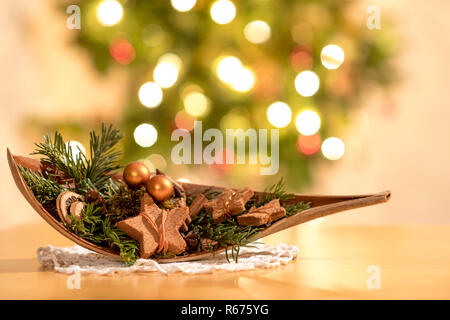 Decorazione di natale in un nutshell nella parte anteriore di un albero di natale con luci di masterizzazione Foto Stock