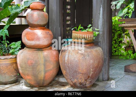 Il vecchio arancione vasetti di terracotta impilati uno accanto ad un palo di legno. Foto Stock