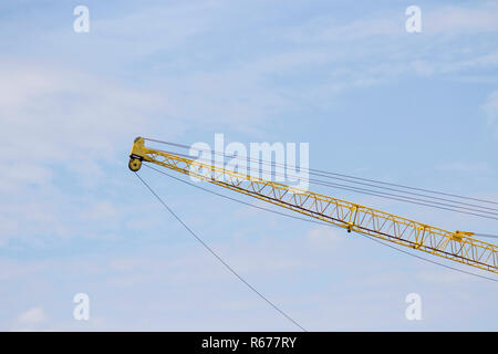 La gru solleva vecchie giallo con il blu del cielo. Foto Stock