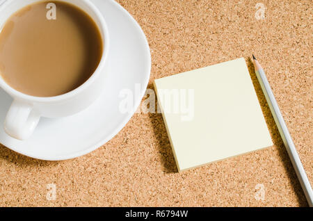 Note vuote e la tazza di caffè sulla bacheca di sughero Foto Stock