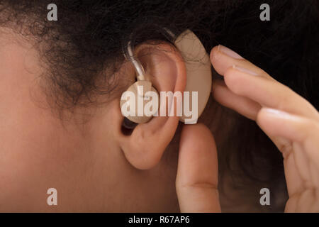 Donna che indossa Hearing Aid Foto Stock