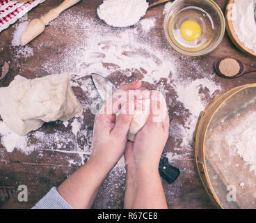 Le mani delle donne mescolare la pasta lievitata da farina di frumento bianca Foto Stock