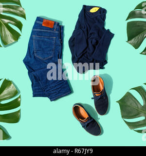 Piatto set laici autunno abbigliamento maschile jeans, pullover e scarpe su sfondo turchese vista superiore Foto Stock