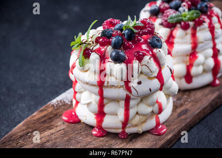 Pavlova con fresche bacche,menta e salsa di fragole. Foto Stock