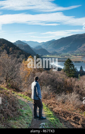 Un escursionista si ferma ad ammirare il paesaggio autunnale vista di Derwentwater nel Lake District mentre salendo fino alla Rupe di Walla in mattina presto luce e beautif Foto Stock