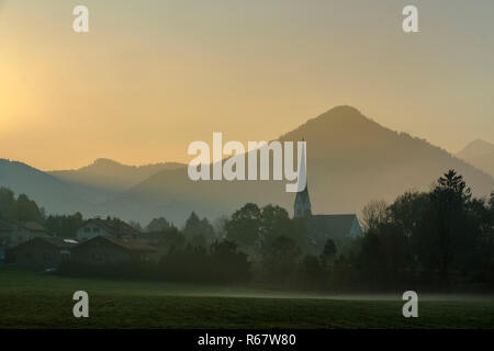 Atmosfera di mattina con la nebbia mattutina, la chiesa di San Martino a Bergen, Schliersee, Alta Baviera, Baviera, Germania Foto Stock