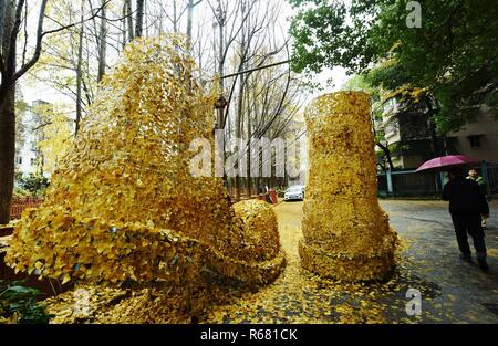 Hangzhou, Hangzhou, Cina. 4° dic, 2018. Hangzhou, Cina-una coppia di gigante " stivali'made di golden foglie di ginkgo può essere visto sulla strada di Hangzhou, Cina. Credito: SIPA Asia/ZUMA filo/Alamy Live News Foto Stock