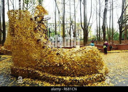 Hangzhou, Hangzhou, Cina. 4° dic, 2018. Hangzhou, Cina-una coppia di gigante " stivali'made di golden foglie di ginkgo può essere visto sulla strada di Hangzhou, Cina. Credito: SIPA Asia/ZUMA filo/Alamy Live News Foto Stock