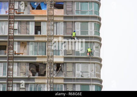 Lavoratore ponteggi sul lato dell'edificio Foto Stock